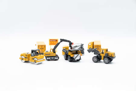 Construction site work vehicles on white background with copy space.
