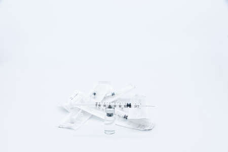 Dose of vaccine against Virus prepared in the syringe placed on the bottle near a group of syringes still packed, isolated on white background.の写真素材