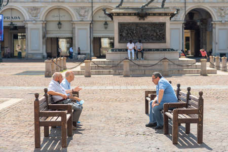 Turin, Italy. June 10, 2021. View of Piazza San Carlo in the morning on a sunny day with local elderly people sitting on the benches.のeditorial素材
