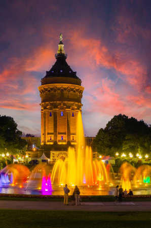 Mannheim, Germany. View of the illuminated Water Tower in Friedrichsplatz at sunset, with fountain creating splendid water and color effects. Vertical image. 2013-06-16.のeditorial素材