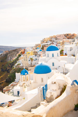 Image of white city on a slope of a hill at sunset, Oia, Santorini, Greece