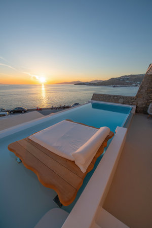 Swimming pool at sunset in luxury hotel on Santorini island, Greeceの写真素材