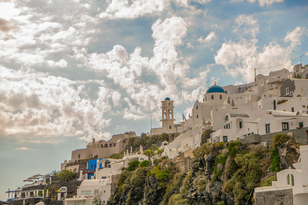 Image of white city on a slope of a hill at sunset, Oia, Santorini, Greeceの写真素材