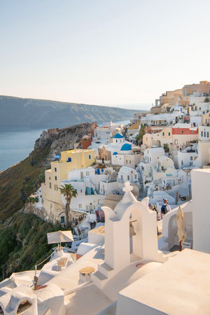 Image of white city on a slope of a hill at sunset, Oia, Santorini, Greeceの写真素材