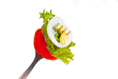 Lettuce, egg and tomato on fork isolatedの写真素材