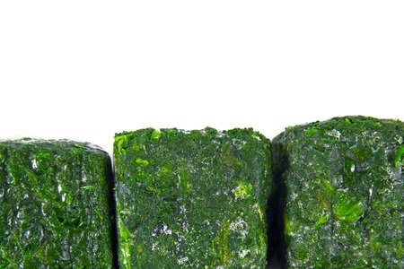 a block of frozen spinach isolated on a white backgroundの写真素材