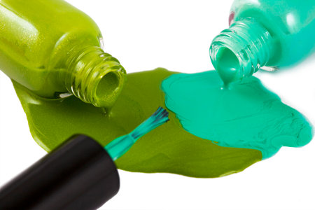 green nail polish bottle with splatters isolated on white backgroundの写真素材