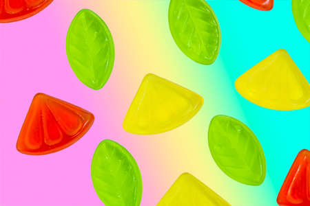 Assorted colorful fruit jelly candy on rainbow backgroundの写真素材