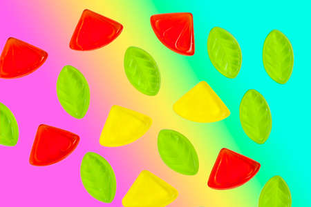 Assorted colorful fruit jelly candy on rainbow background