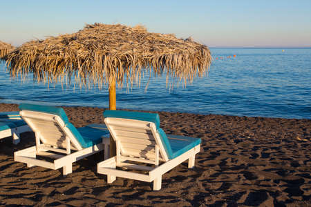 Umbrellas on the beach in Perissa, sunset time, Greeceの写真素材