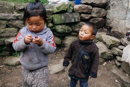 HIMALAYAS, EVEREST REGION, NEPAL - OCTOBER 20, 2018: Portrait nepalese children near their house, on the street in Himalayan village, Nepalのeditorial素材