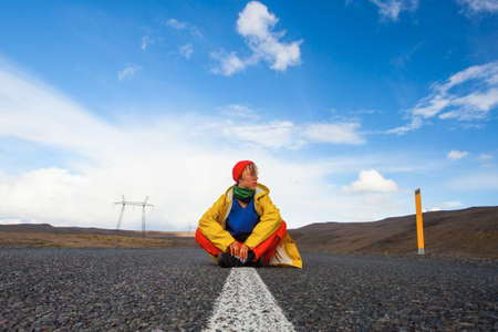 Happy tourist woman in bright clothes and yellow coat, enjoying traveling Iceland