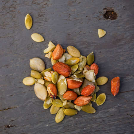 Raw peeled peanuts and pumpkin seeds on the wooden tableの写真素材