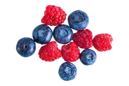 Fresh bright raspberries and blueberries heap isolatedの写真素材