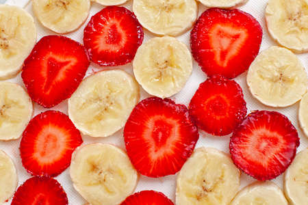 Fresh green sliced banana and strawberry background - healthy foodの写真素材