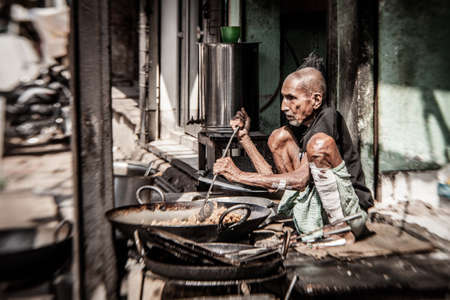 VARANASI, INDIA - NOVEMBER 2 - Unidentified man cooks meal for sale in street restaurant in Varanasi, November 2 2013.のeditorial素材