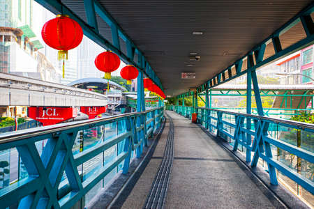Kuala Lumpur, Federal Territory, Malaysia - January 21,2020: Overhead pedestrian walking bridge with traditional chinese red lamps leads to nearby facilities.のeditorial素材