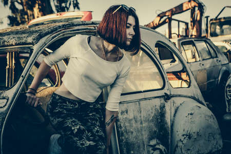 beautiful young girl poses near retro carの写真素材