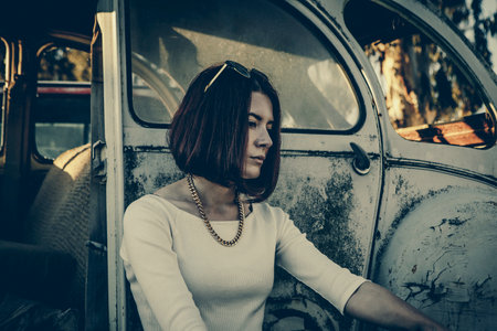 beautiful young girl poses near retro carの写真素材