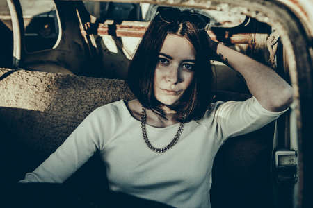 beautiful young girl poses near retro car