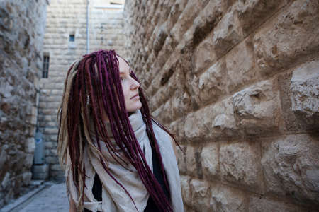 Portrait of a young woman with pink dreadlocks in Old Jerusalem