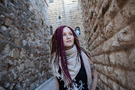 Portrait of a young woman with pink dreadlocks in Old Jerusalem