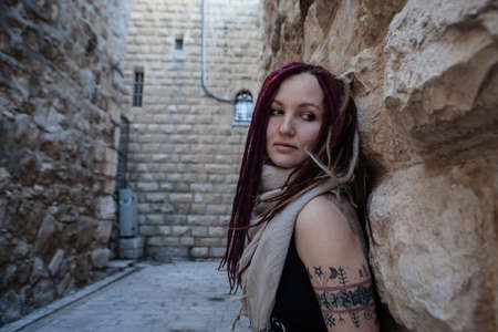 Portrait of a young woman with pink dreadlocks in Old Jerusalem