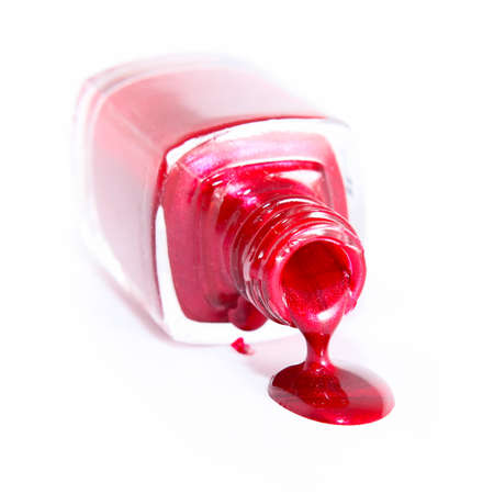 Red nail polish and bottle on white