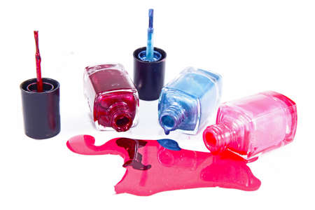 Bottles with spilled nail polish over white background