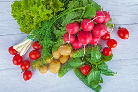 Fresh vegetables : adish, tomatoes ets, on light wooden background
