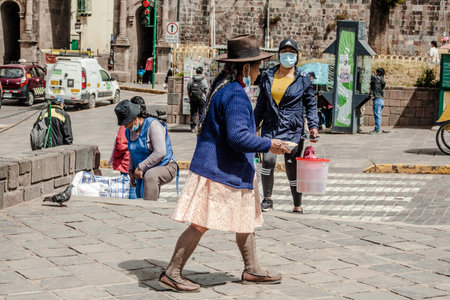 PERU - MAY 15, 2022: Peruvian people in traditional clothes  in Cuzco. Woman selling traditional food Tamalr in Cusco, Peru, May 15, 2022のeditorial素材