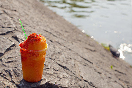Sweet ice sorbet with mango taste with pepper chili powder and spices - Mexican traditional stret foodの写真素材