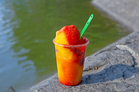 Sweet ice sorbet with mango taste with pepper chili powder and spices - Mexican traditional stret...