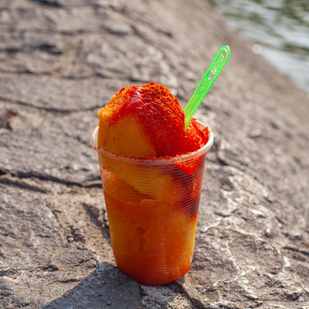 Sweet ice sorbet with mango taste with pepper chili powder and spices - Mexican traditional stret foodの写真素材
