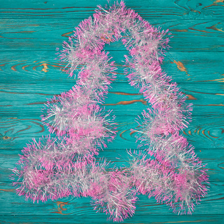 White and pink garland in christmas tree form on turquoise wooden backgroundの写真素材
