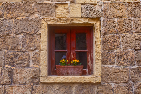 window with flowerpots on the Narrow street of ancient city Rabat with traditional maltese houses built of limestone, Victoria, Maltaの写真素材