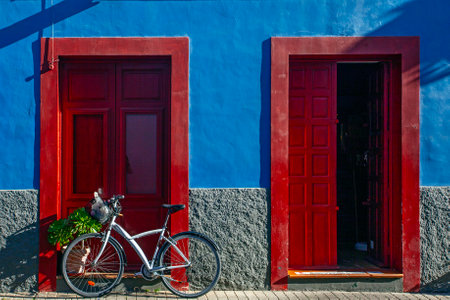 Buildings, street and parked bicycle on blue sky background. Colonial style of the city. Houses painted with various bright colors.の写真素材