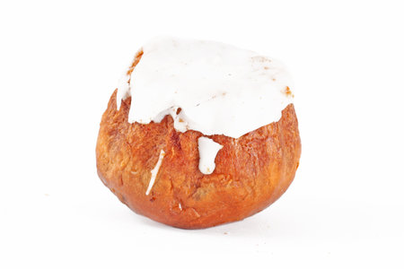 Cake with white chocolate glaze in a paper cup on a white insulated backgroundの写真素材