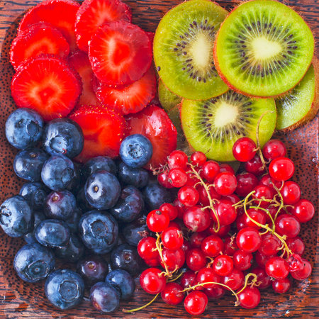 Fruits and berries on the wooden plateの写真素材