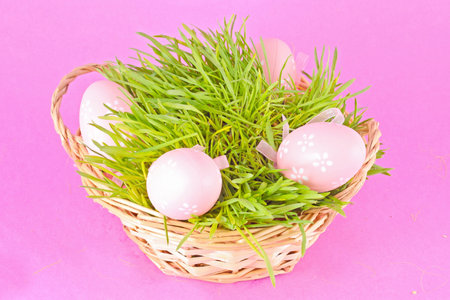 Colorful painted easter eggs in basket on the lilac backgroundの写真素材