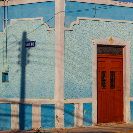 Merida, Yucatan, Mexico - 4 April, 2022: Street of Merida, Small bright light blue  colonial house with shadowsの写真素材