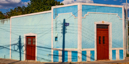 Merida, Yucatan, Mexico - 4 April, 2022: Street of Merida, Small bright light blue  colonial house with shadowsの写真素材