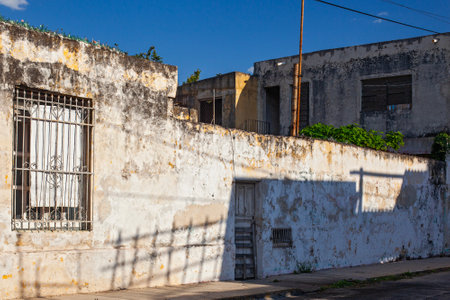 Merida, Yucatan, Mexico - 4 April, 2022: Small pastel colored colonial house with a washed out facadeの写真素材