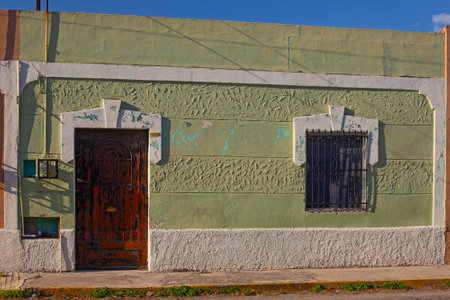 Merida, Yucatan, Mexico - 4 April, 2022: Small pastel colored colonial house with a washed out facadeの写真素材