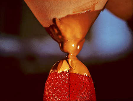 A womans breast, some melted chocolate and a strawberry.