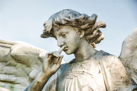 A pretty young male stone angel contemplating things.の写真素材