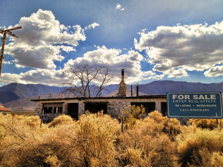An abandoned crumbling house for sale in a California desert.の写真素材