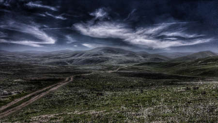 A moonlit road through green hills.の写真素材