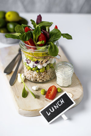 Homemade barley groats salad with goat cheese in a jarの写真素材