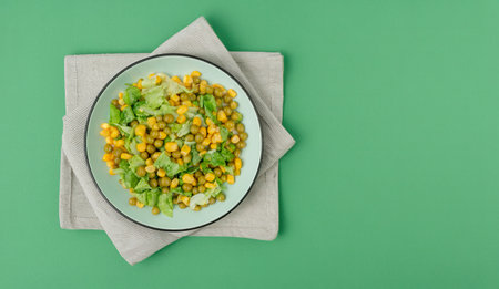 top view of plate of yellow pea and sliced lettuce with corn spinach lettuce salt on cloth